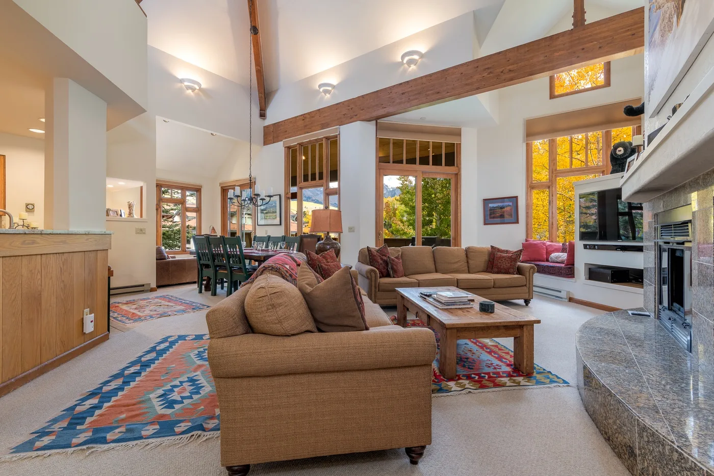 A spacious living room with seating, a coffee table, and large windows.