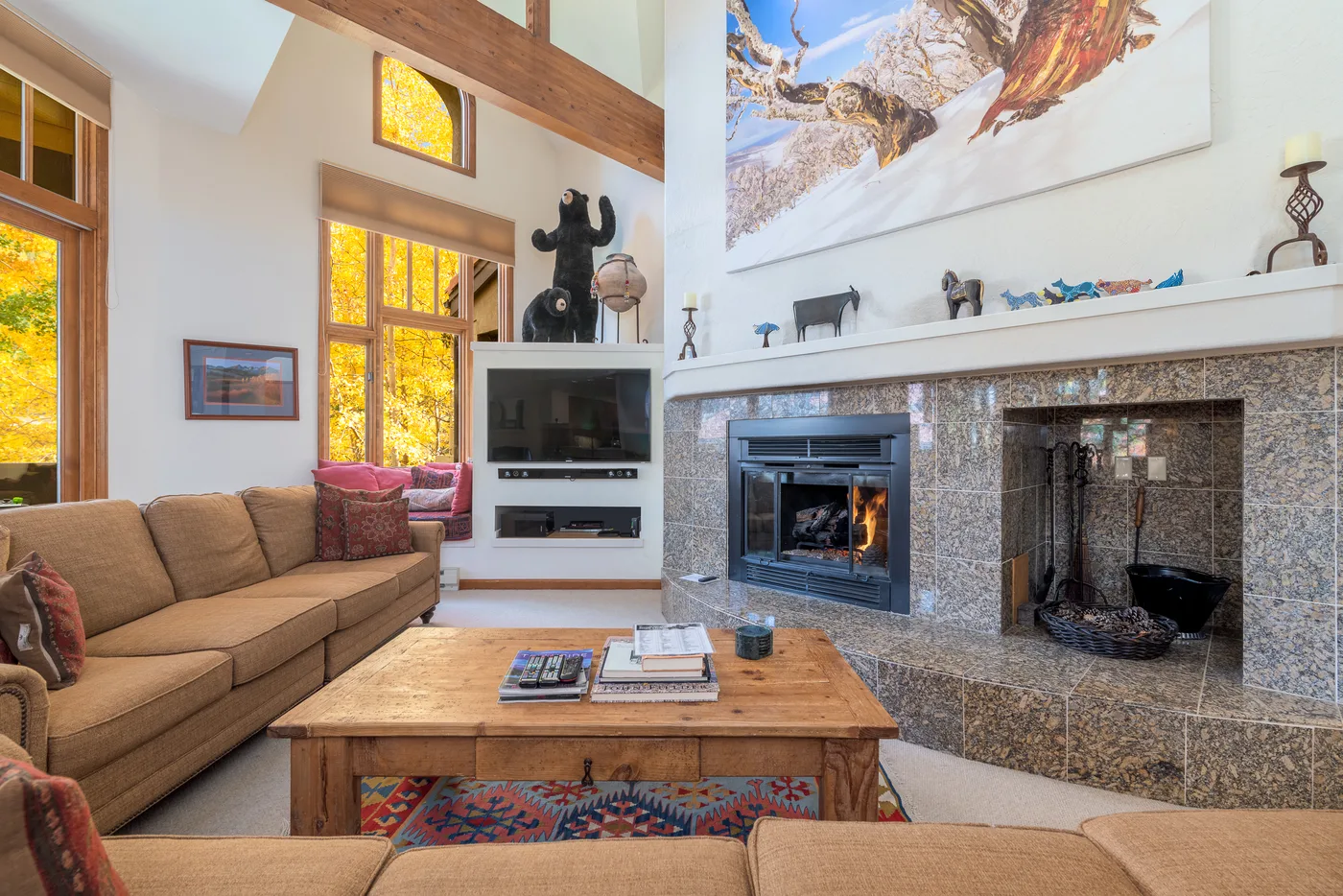 A living room with a fireplace, seating, and a wooden coffee table.