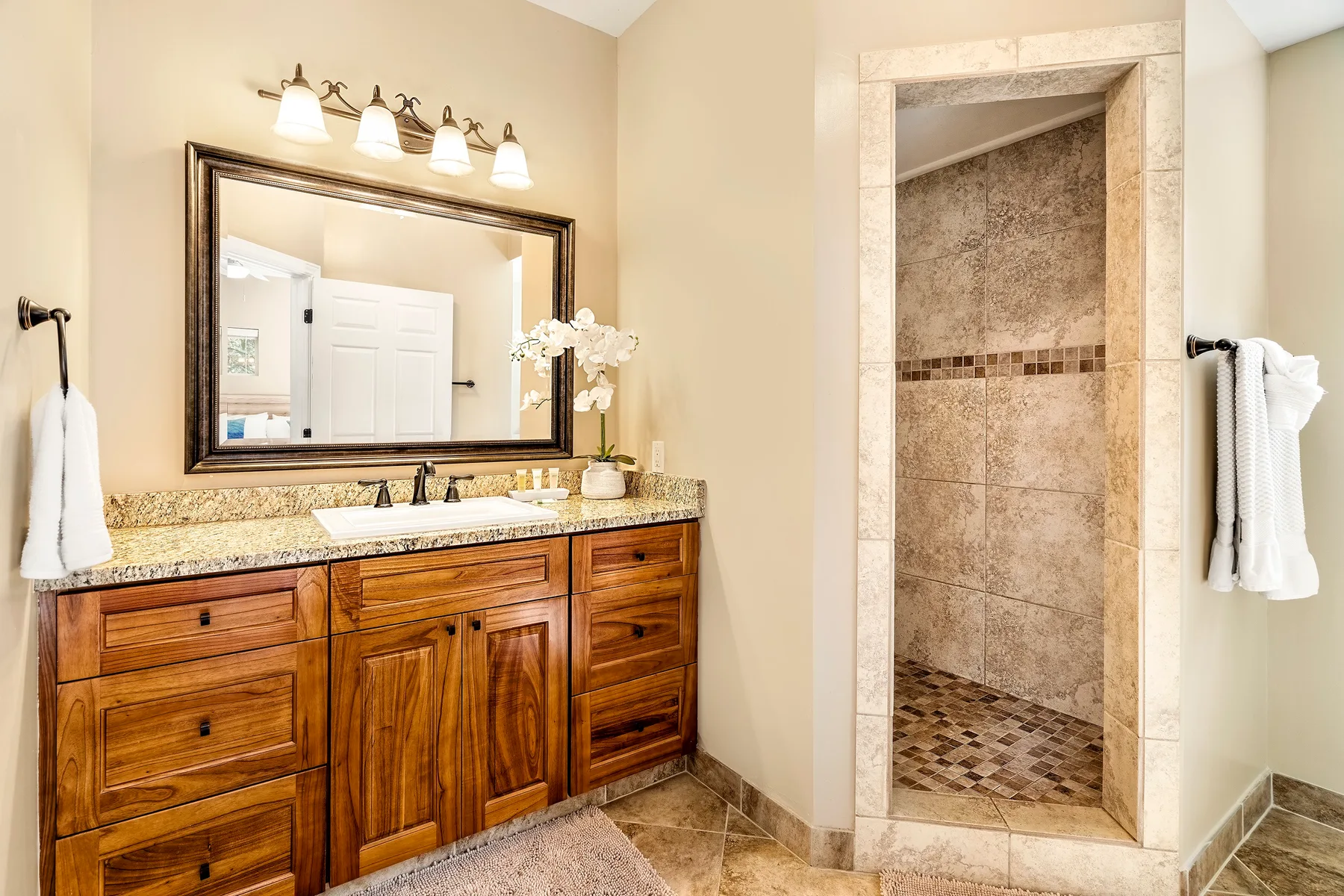 Un tocador de baño con lavabo está junto a una ducha con azulejos.