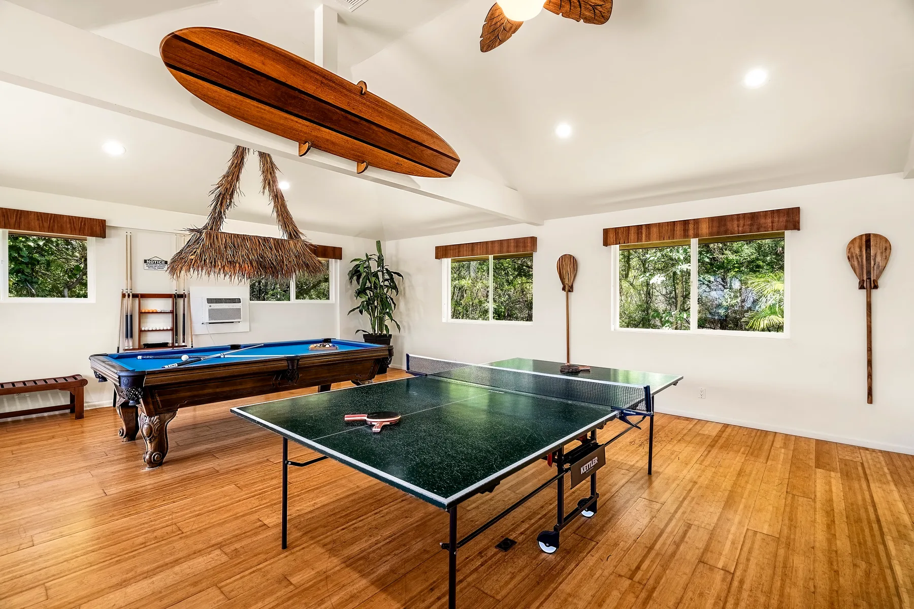 Una luminosa sala de juegos con una mesa de billar y una mesa de ping-pong.