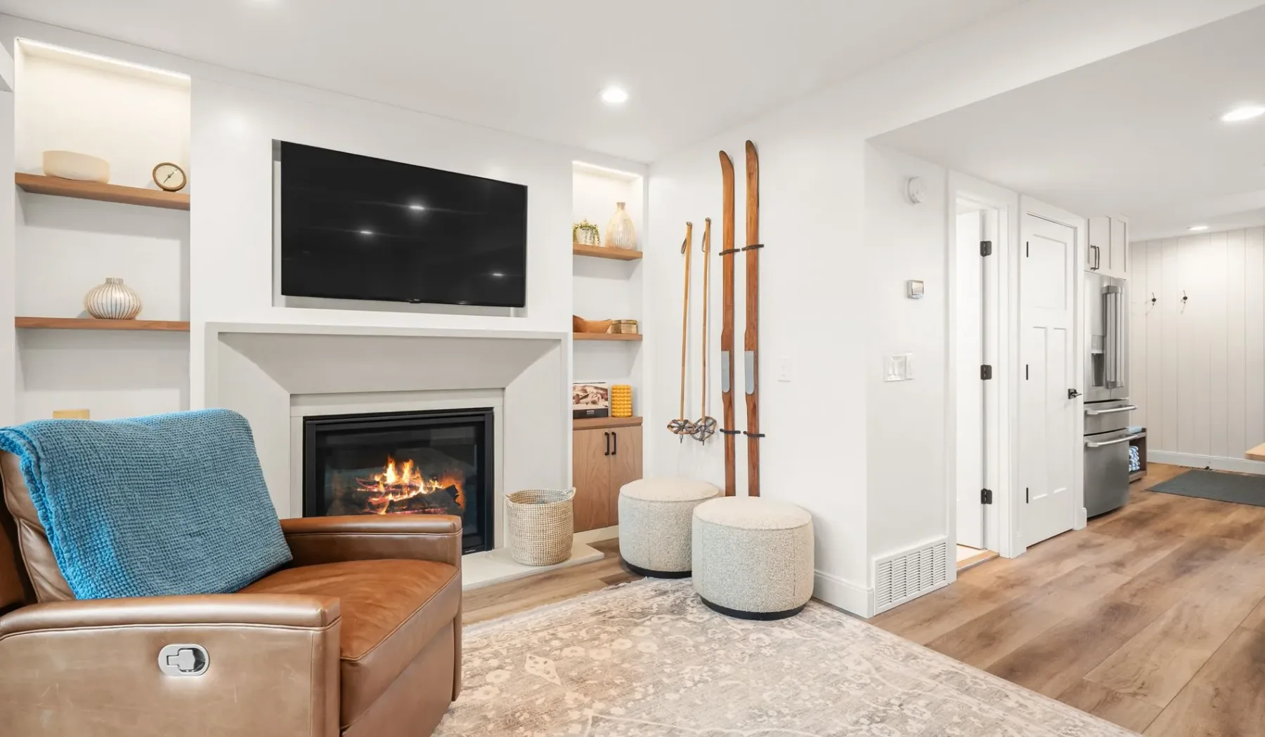 Una sala luminosa con chimenea, televisor montado en la pared y asientos.