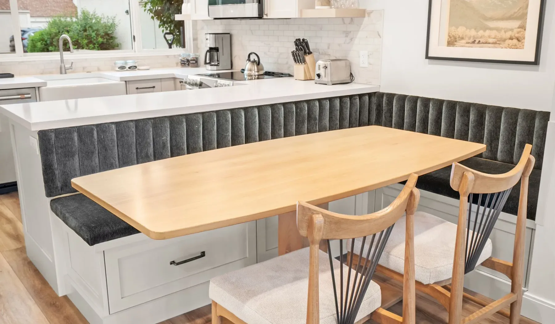 Una isla de cocina con una mesa de comedor de madera clara y asientos.