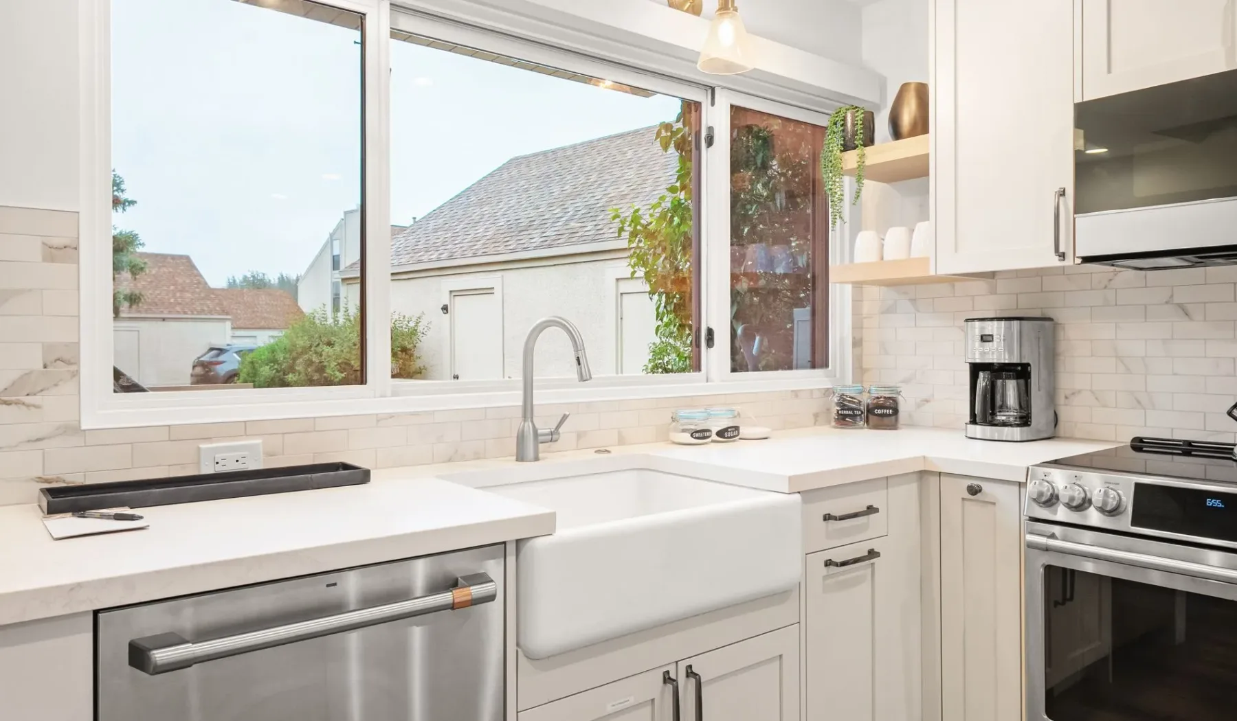 Una cocina luminosa con una ventana grande sobre el fregadero y las encimeras.