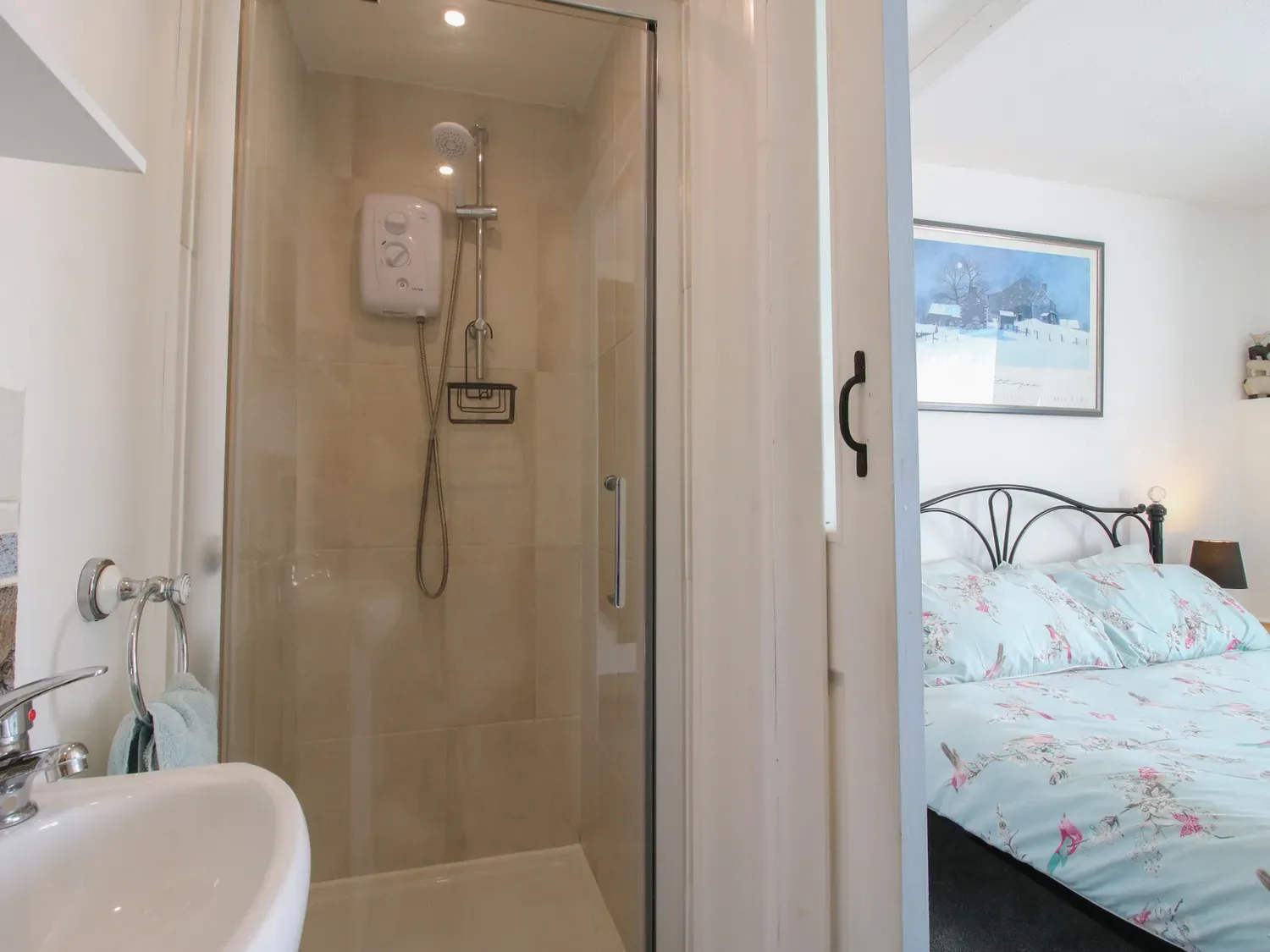 Un baño con ducha y lavabo junto a un dormitorio con una cama y un cuadro enmarcado en la pared en The Old Beams, en Pont y Forwyn, Llansantffraidd-ym-Mechain, cerca de Welshpool.