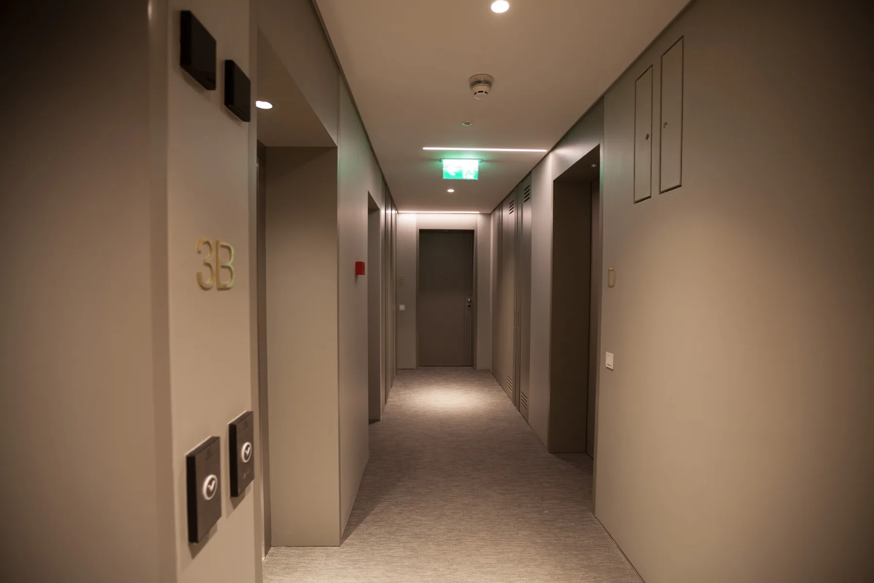A softly lit interior hallway with a door at the far end.