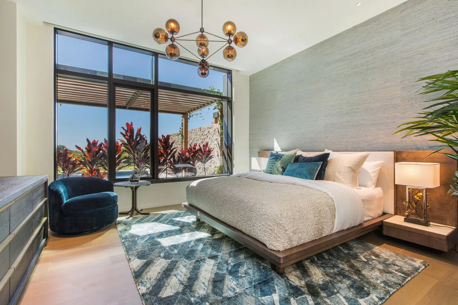 A bedroom with a large bed beside floor-to-ceiling windows.