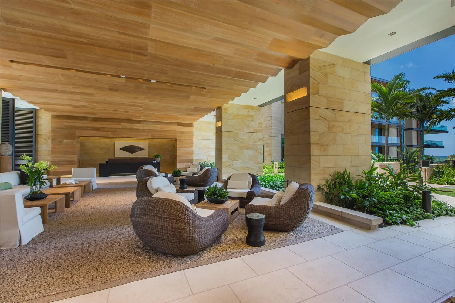 A covered outdoor lounge with cushioned seating and a low table.