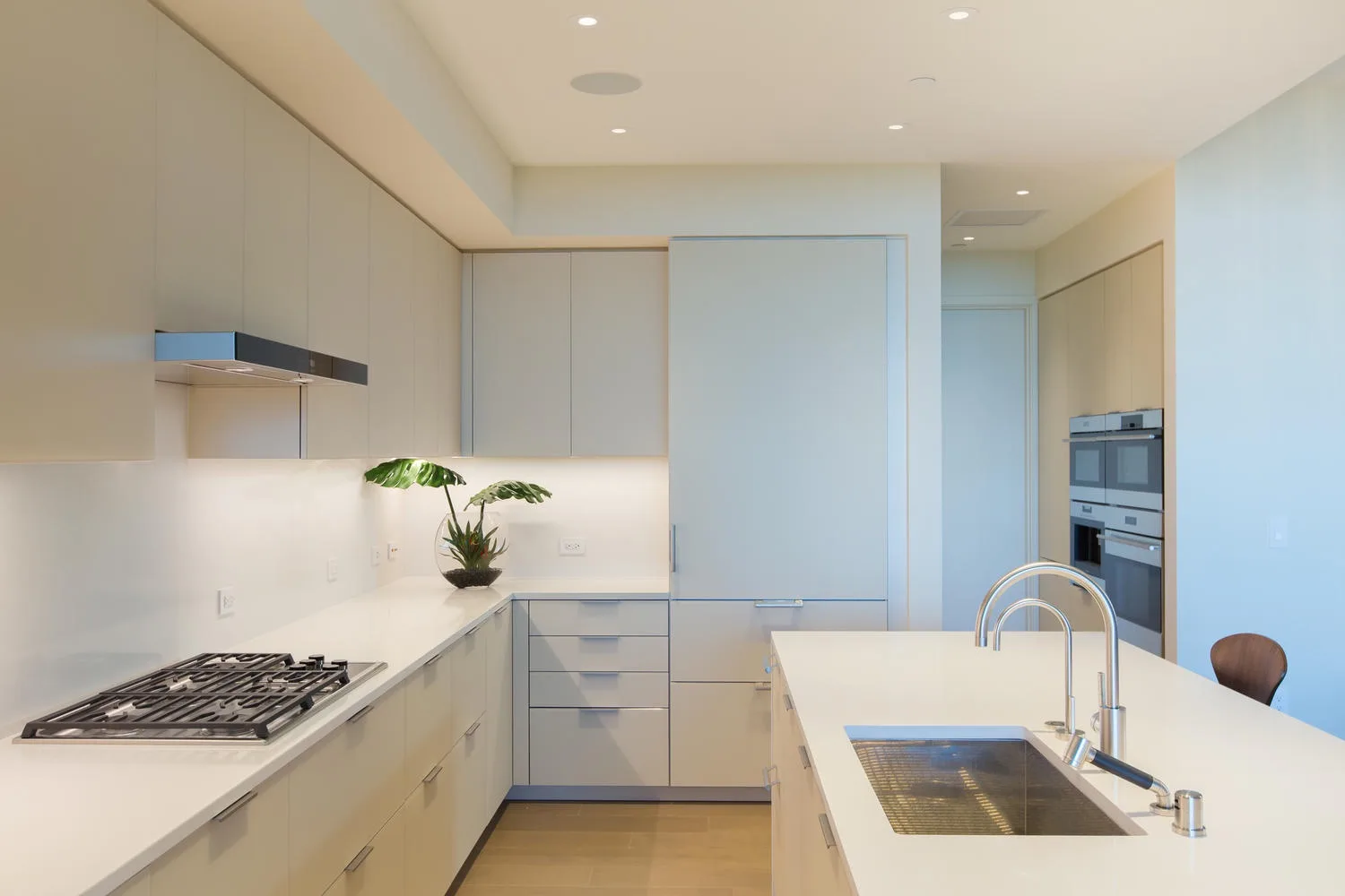 A modern kitchen with pale cabinetry and a large island.