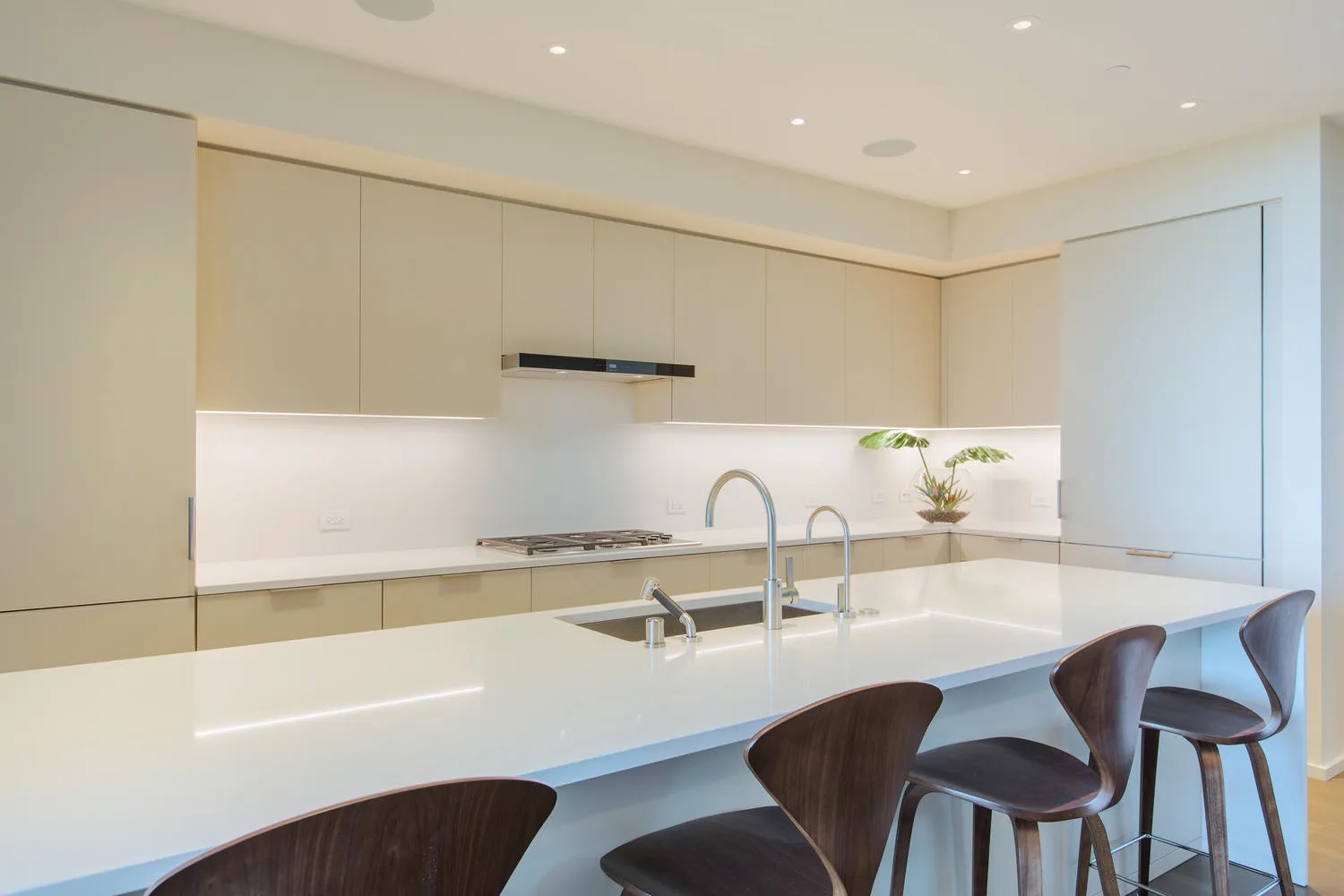 Una cocina moderna y luminosa con una isla larga y asientos de barra.