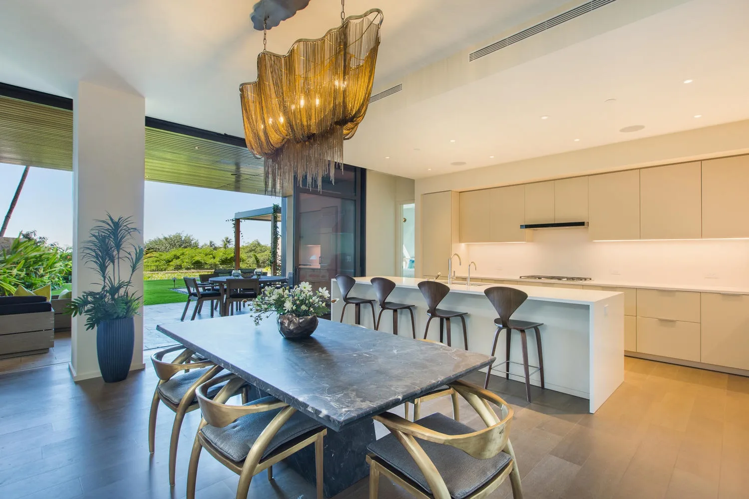 A modern dining and kitchen area with a long table and an island.