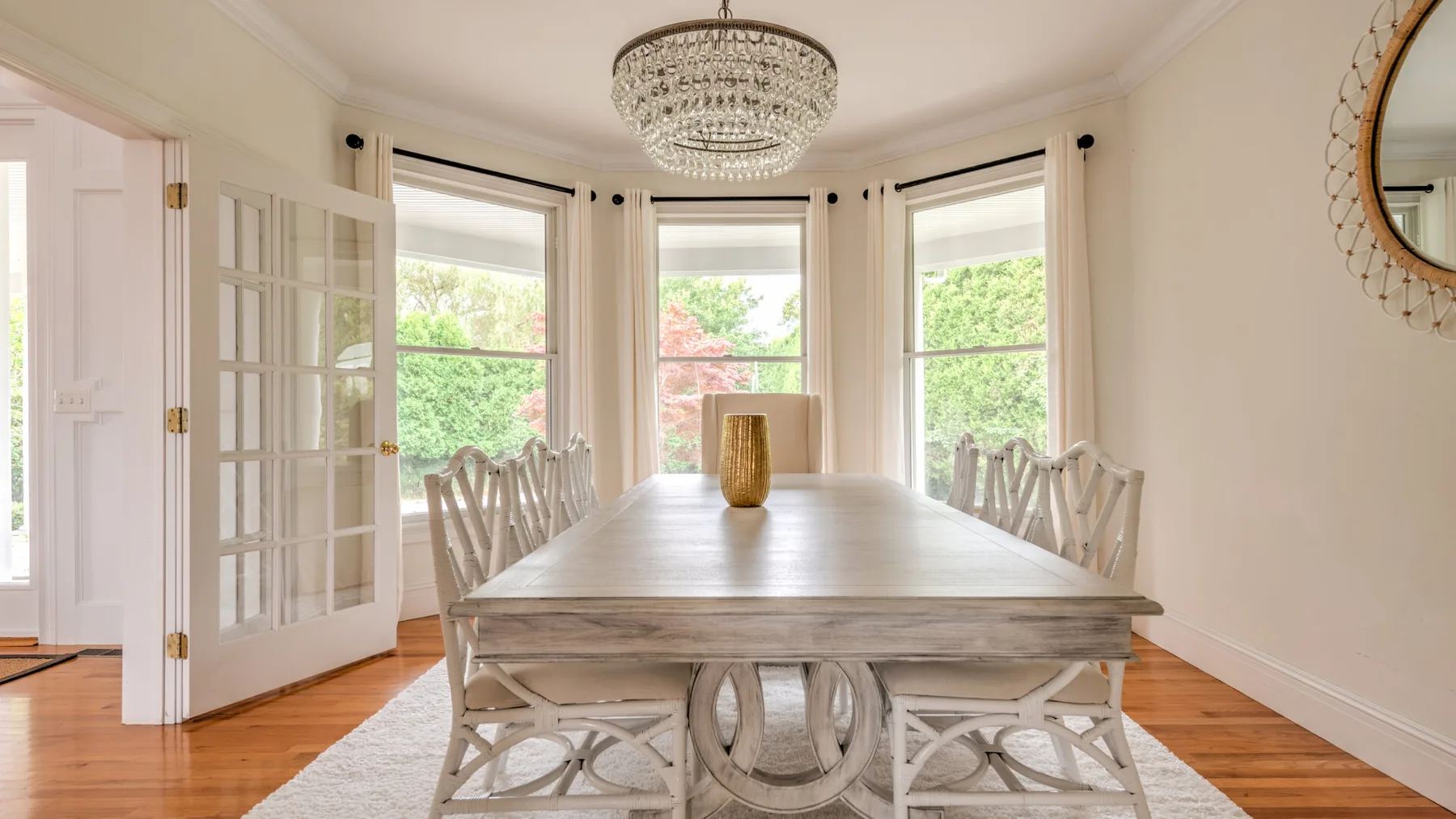 Un comedor luminoso con una mesa larga junto a grandes ventanas.