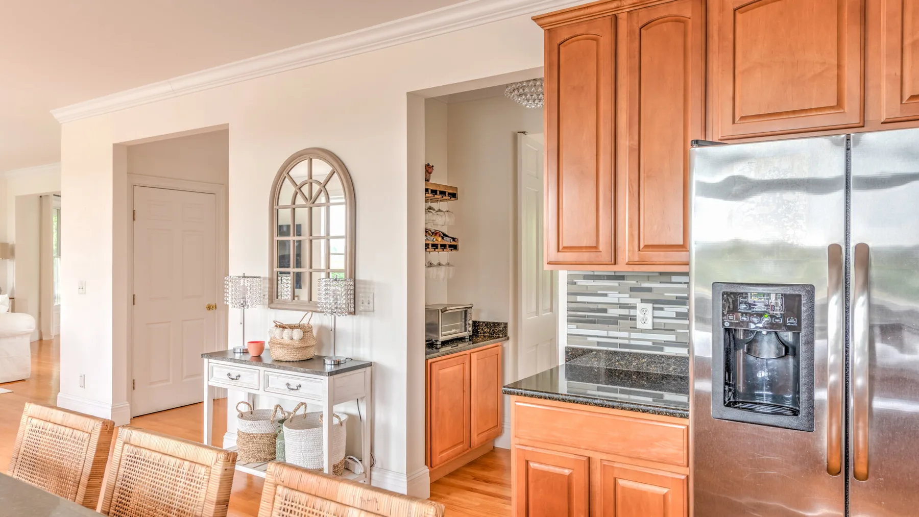 Una cocina luminosa con gabinetes de madera y un refrigerador de acero inoxidable.