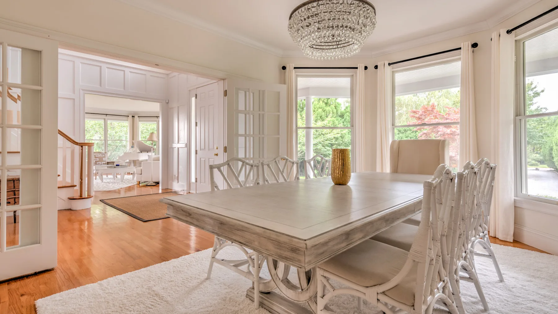 Un comedor luminoso con una mesa larga y grandes ventanas.