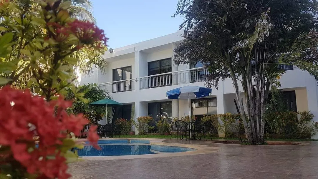 Hotel building with a pool in front.