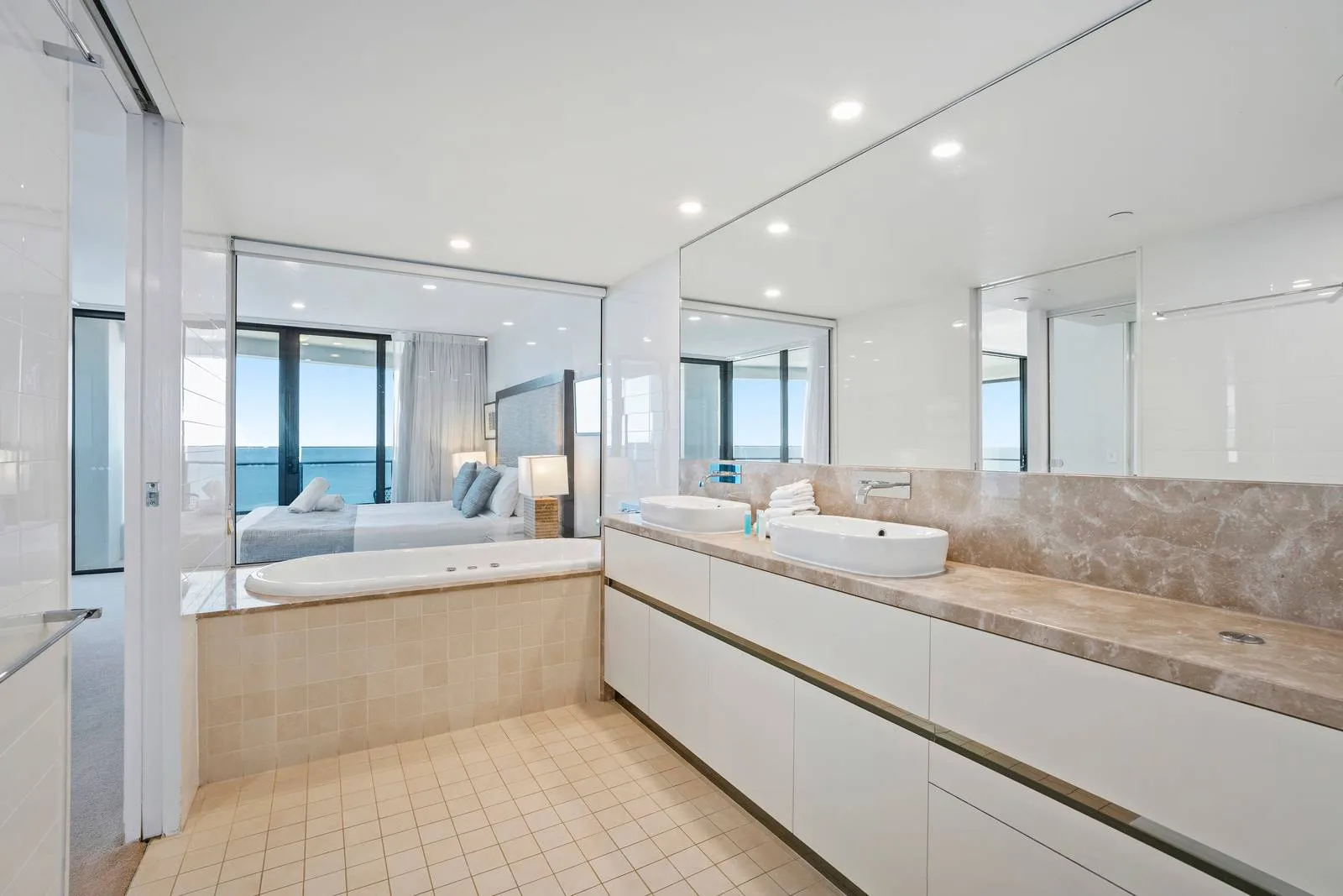 Baño luminoso con bañera y un amplio lavabo frente al océano.