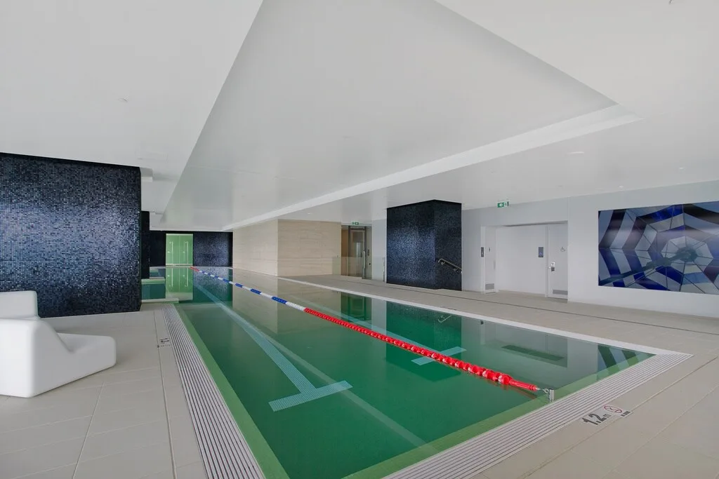 Una piscina cubierta con marcas de carril y asientos junto al borde.