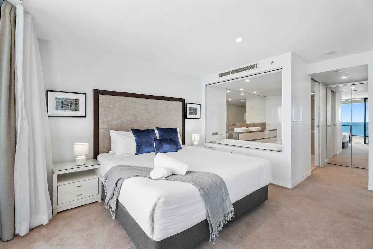 Un dormitorio luminoso con una cama y una gran ventana interior.