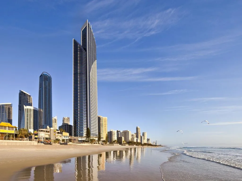 Un horizonte costero de edificios altos se alza junto a una playa de arena y el océano.