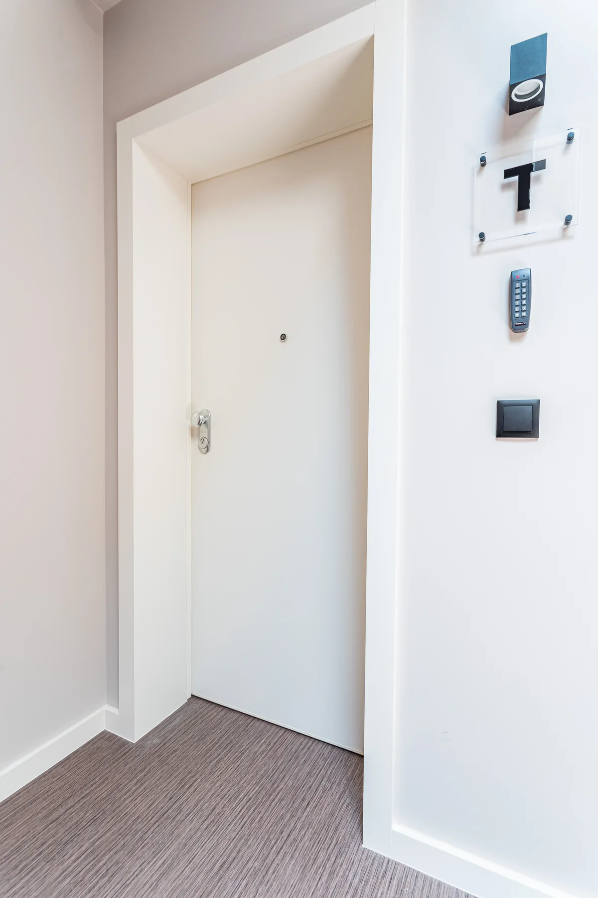 A white entry door set in a recessed hallway.
