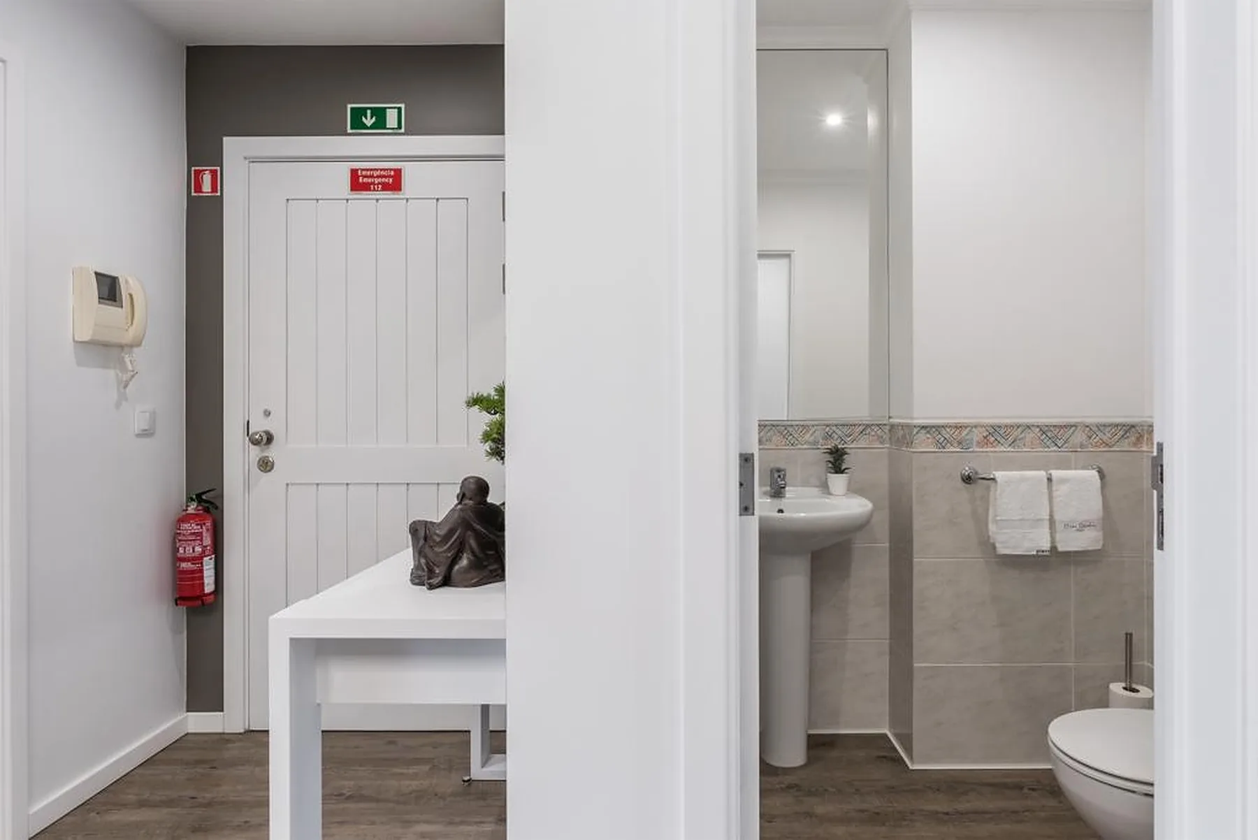 A bathroom with a sink and toilet is visible beside an entryway.