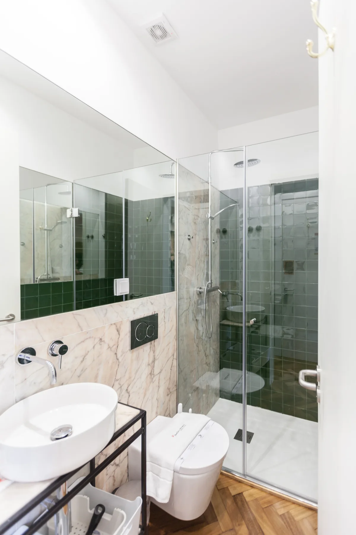 A bathroom with a glass shower, sink, and toilet.