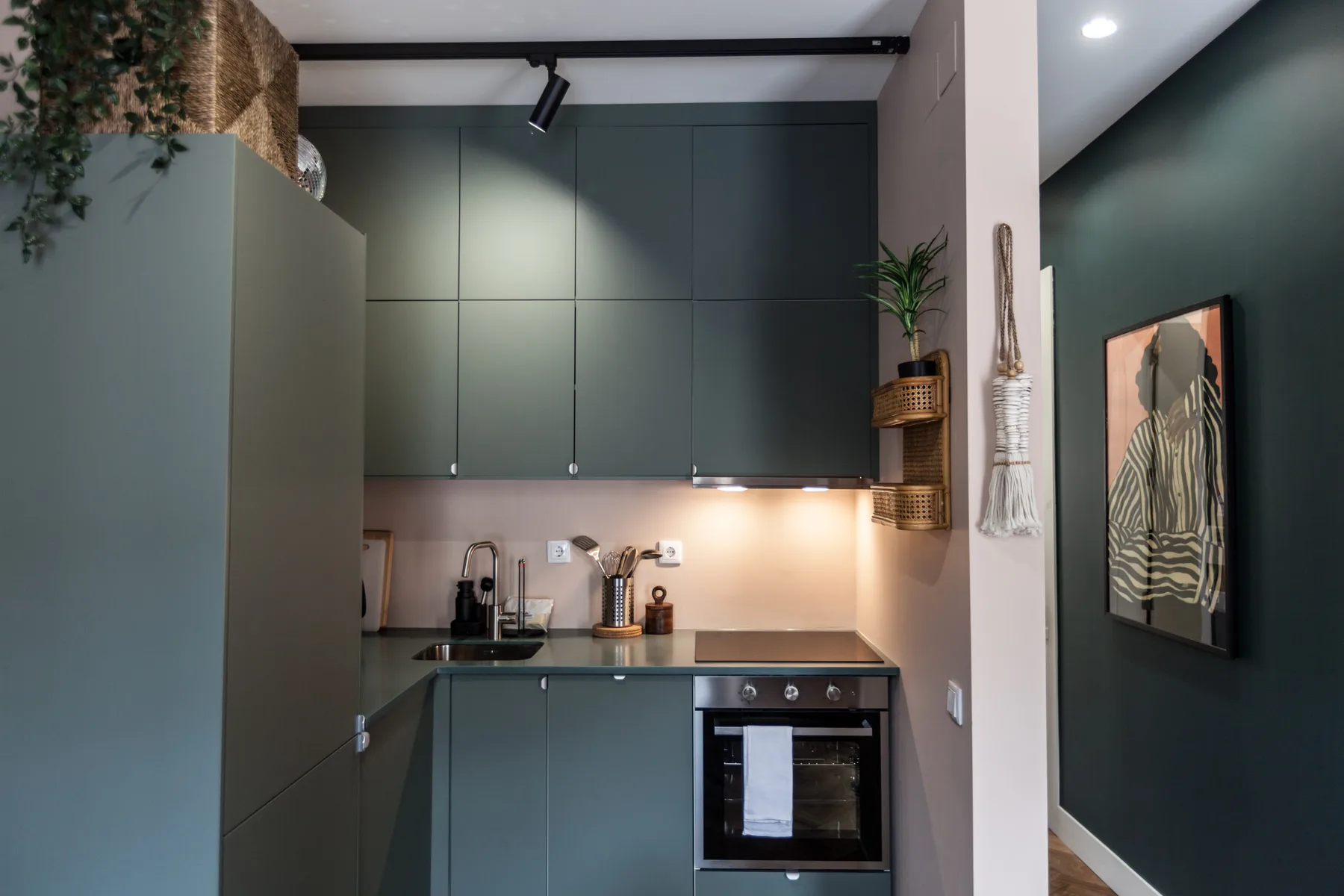 A compact kitchen with dark cabinets, a countertop, and an oven.