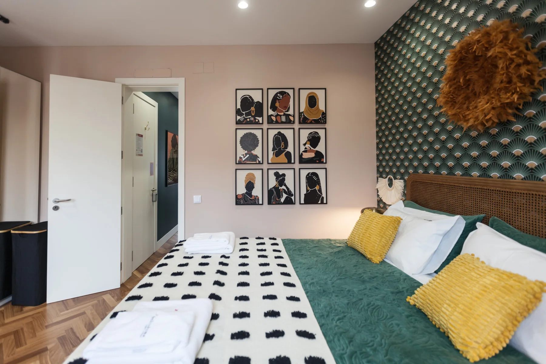 Bedroom with a bed dressed in teal and patterned bedding.