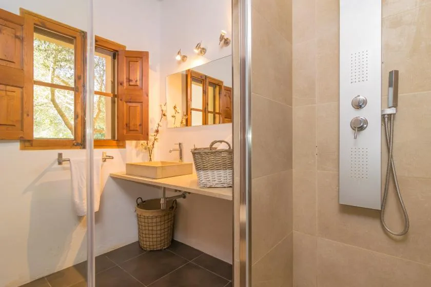 A tiled bathroom with a vanity, mirror, and shower.