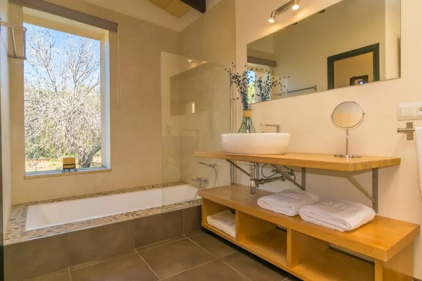 A bathroom with a bathtub, a sink, and a large window.