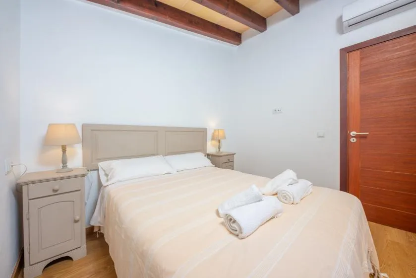 A bedroom with a neatly made bed and bedside tables.