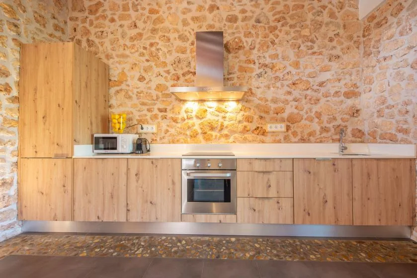 A kitchen with light wood cabinetry, a countertop, and a built-in oven.