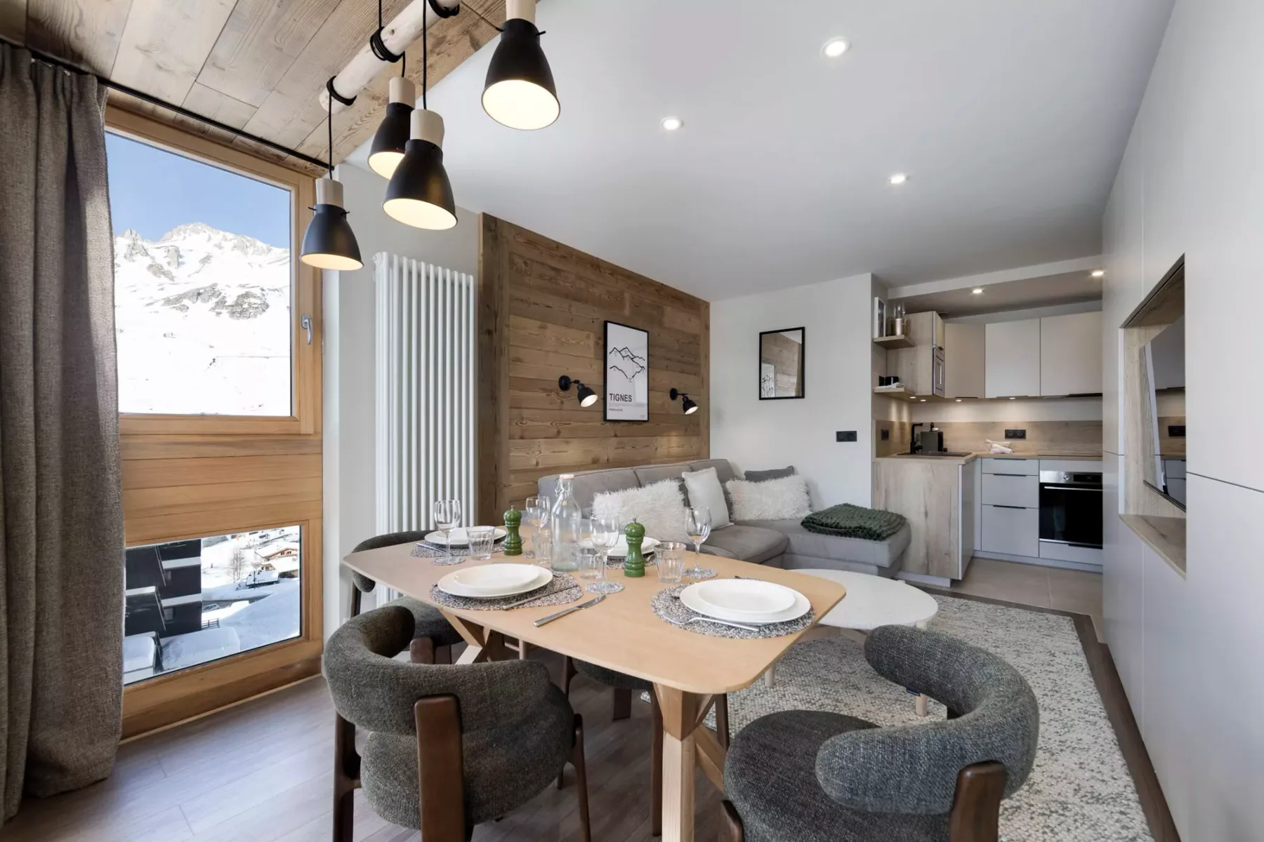 Un comedor con mesa y asientos se abre a una cocina compacta.