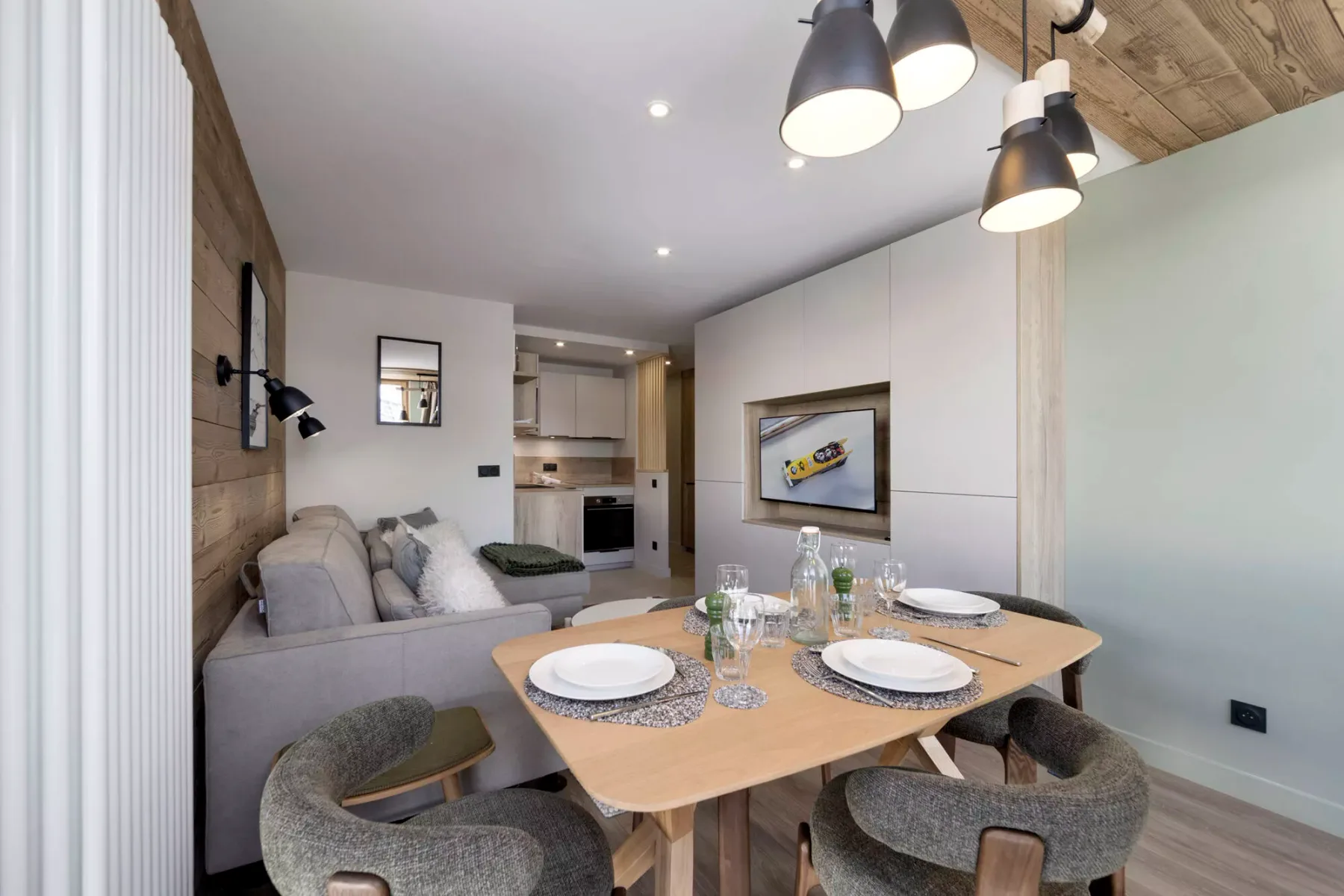 Una zona de comedor y estar con una mesa junto a un sofá.