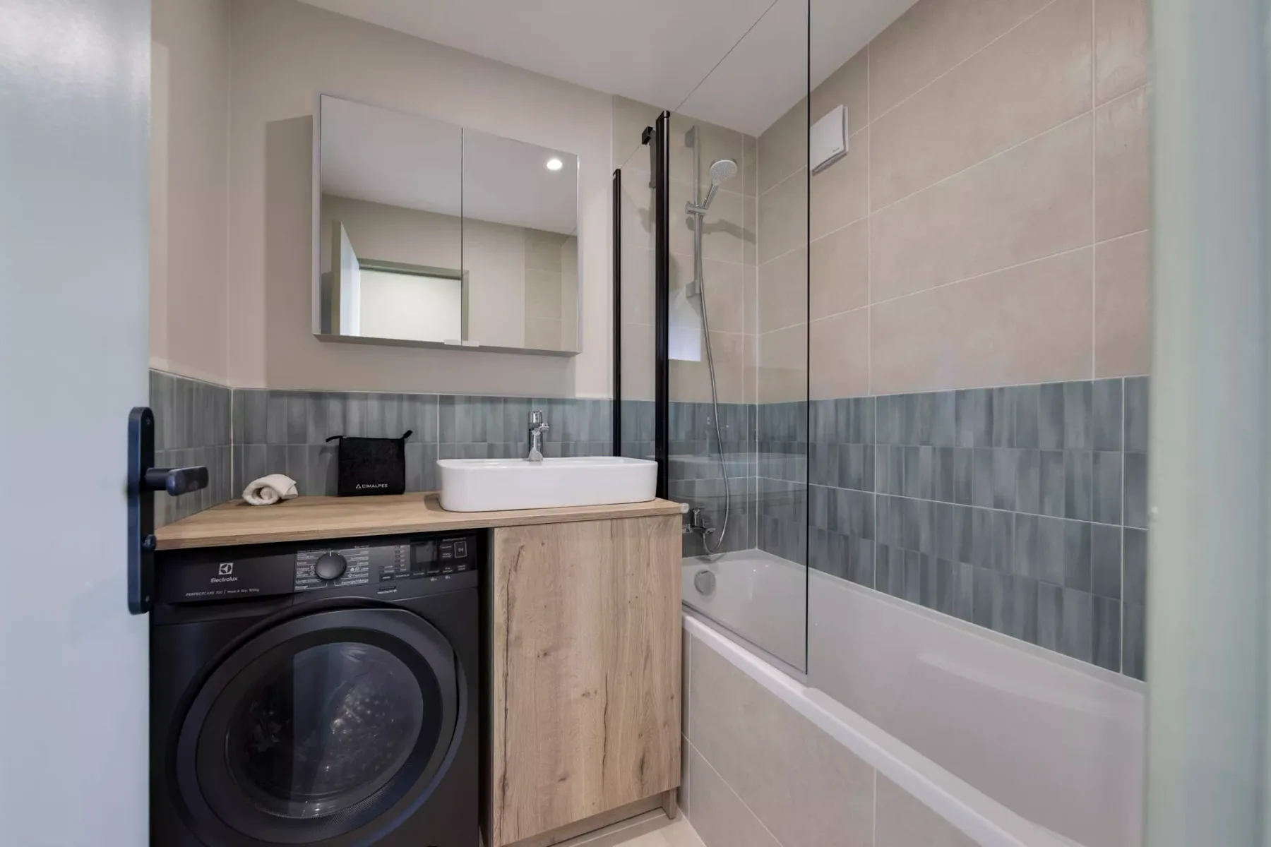 Un baño con bañera, ducha, lavabo y lavadora.
