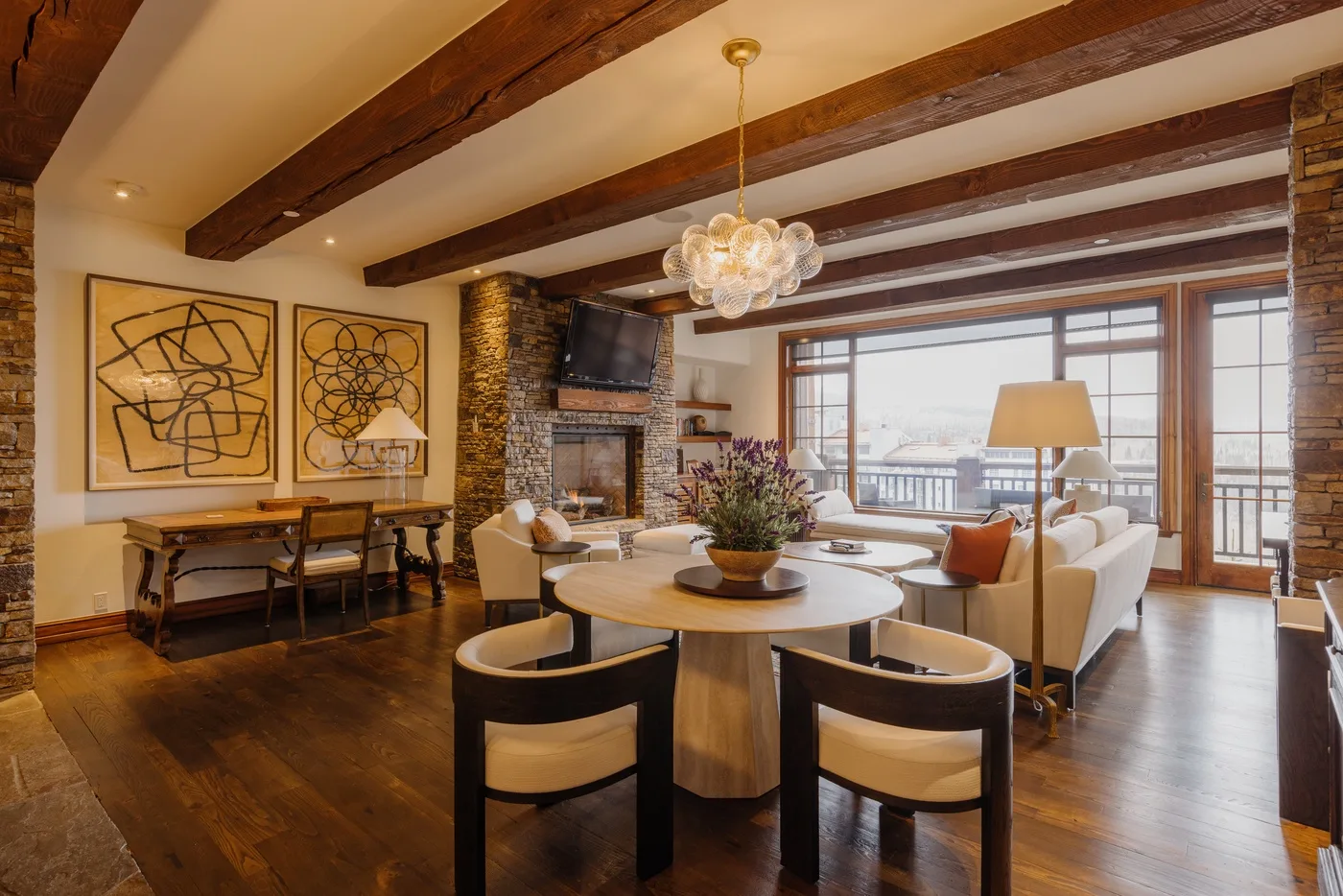 Sala de estar y comedor con vigas de madera a la vista y ventanas amplias.