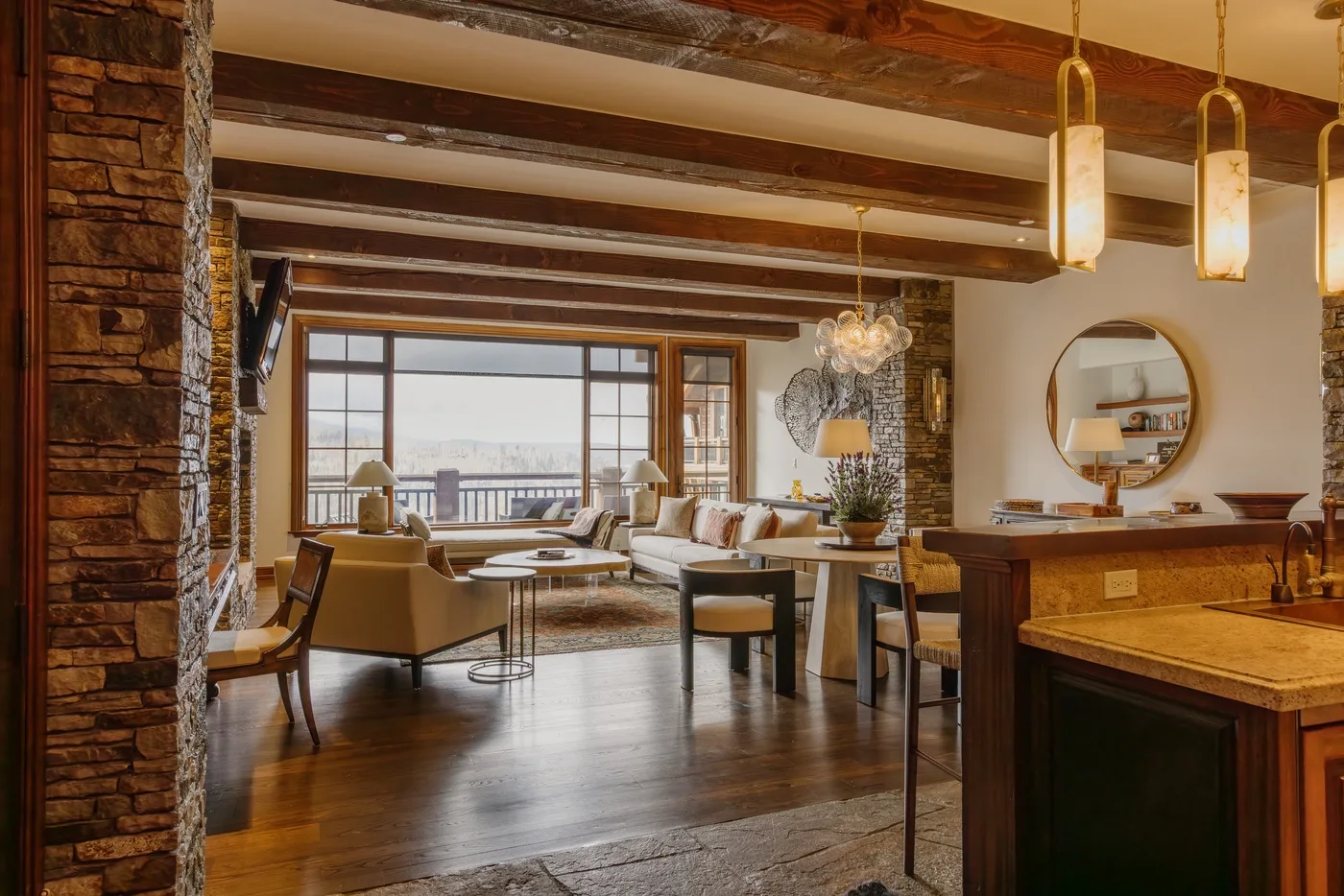 An open-plan living and dining area with a kitchen counter and large windows.