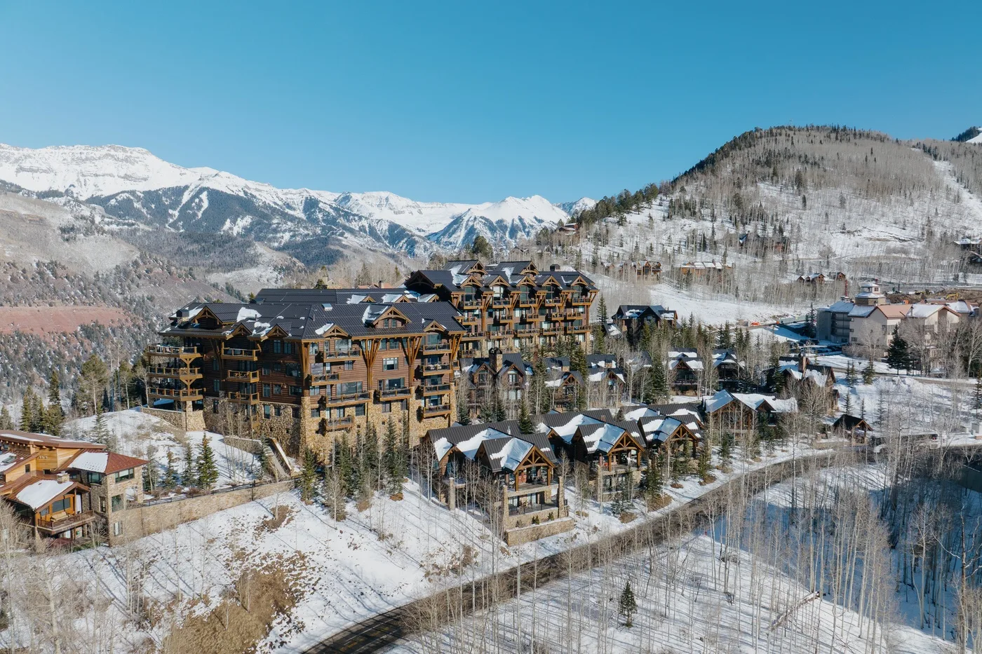 A mountain resort village with clustered buildings beneath snow-covered peaks.