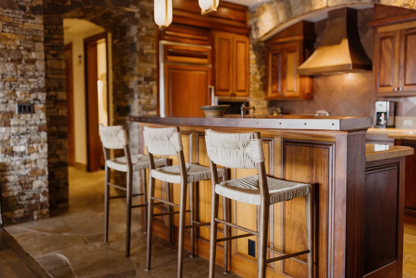Una cocina con una isla de madera y asientos de barra.