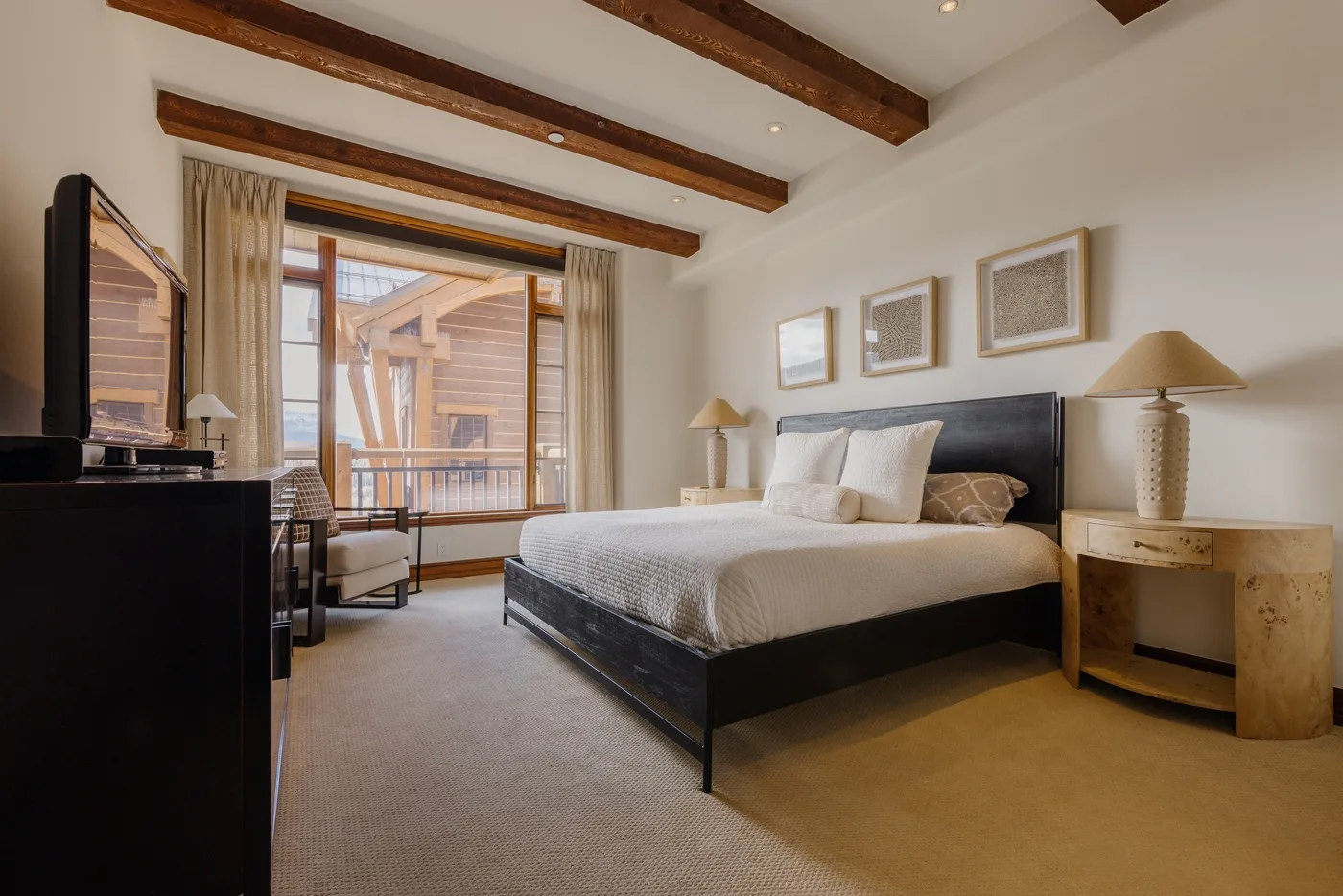A bright bedroom with a large bed and sliding glass doors opening onto a balcony.