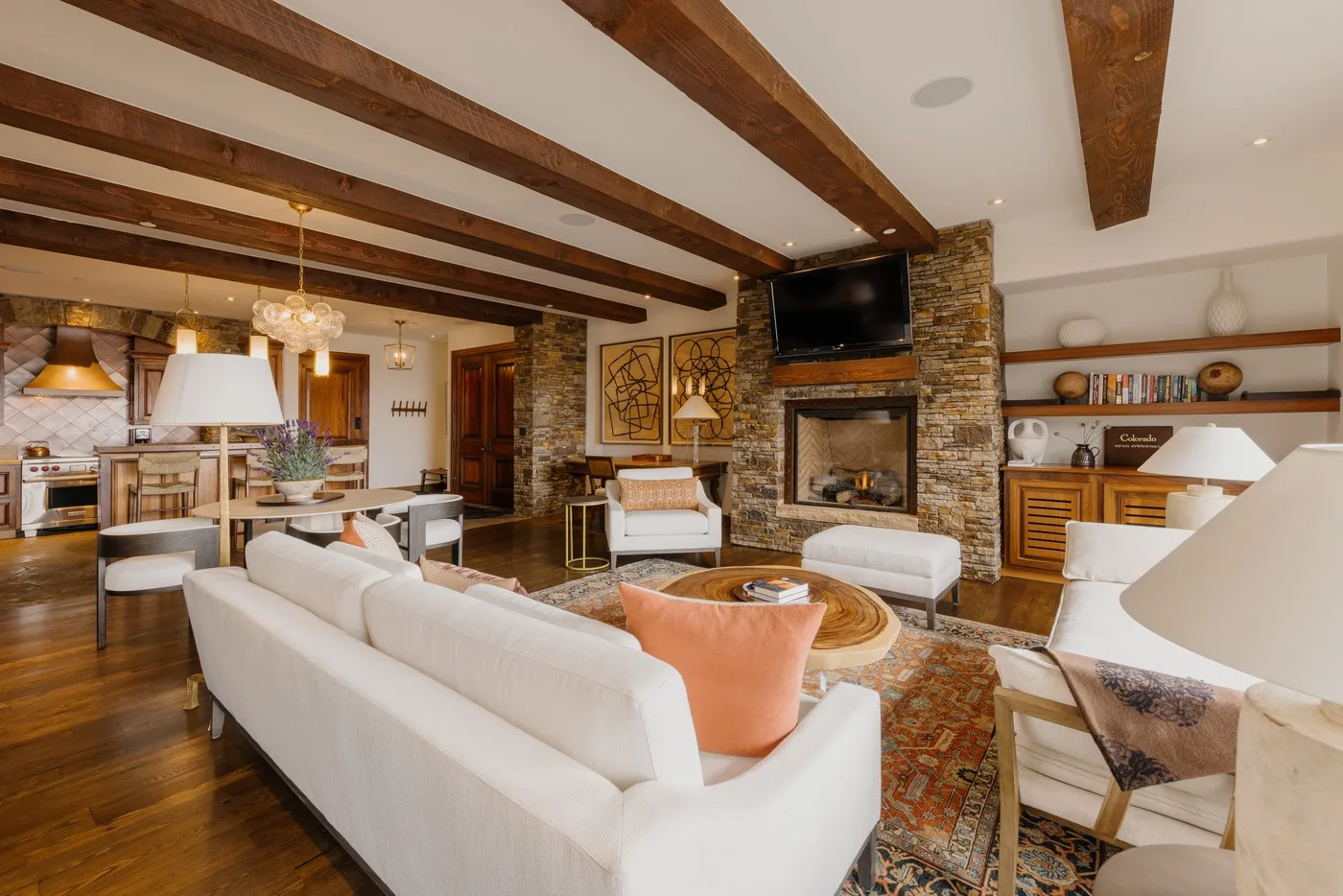 A living room with seating arranged around a fireplace and television.