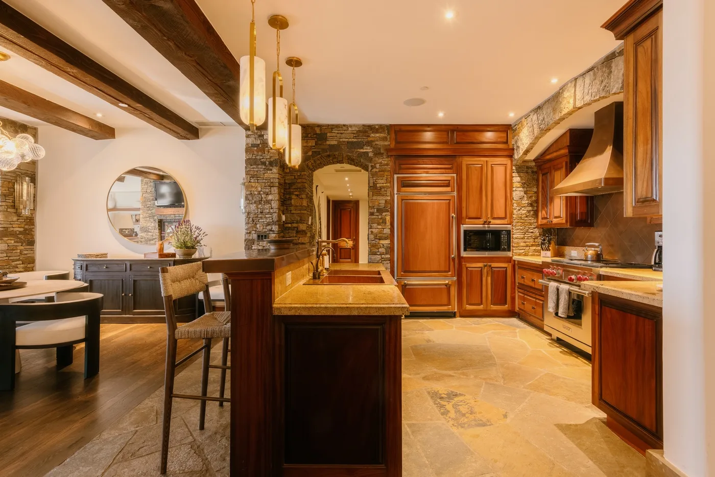 A spacious kitchen with a central island, wooden cabinetry, and dining seating.