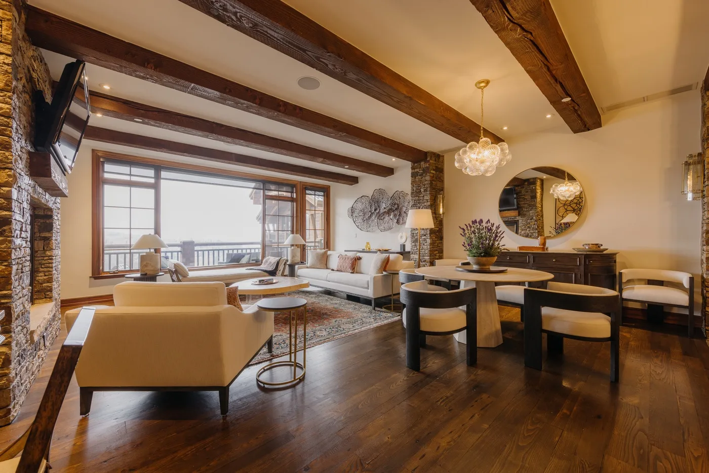 A spacious living and dining area with seating, a table, and large windows.
