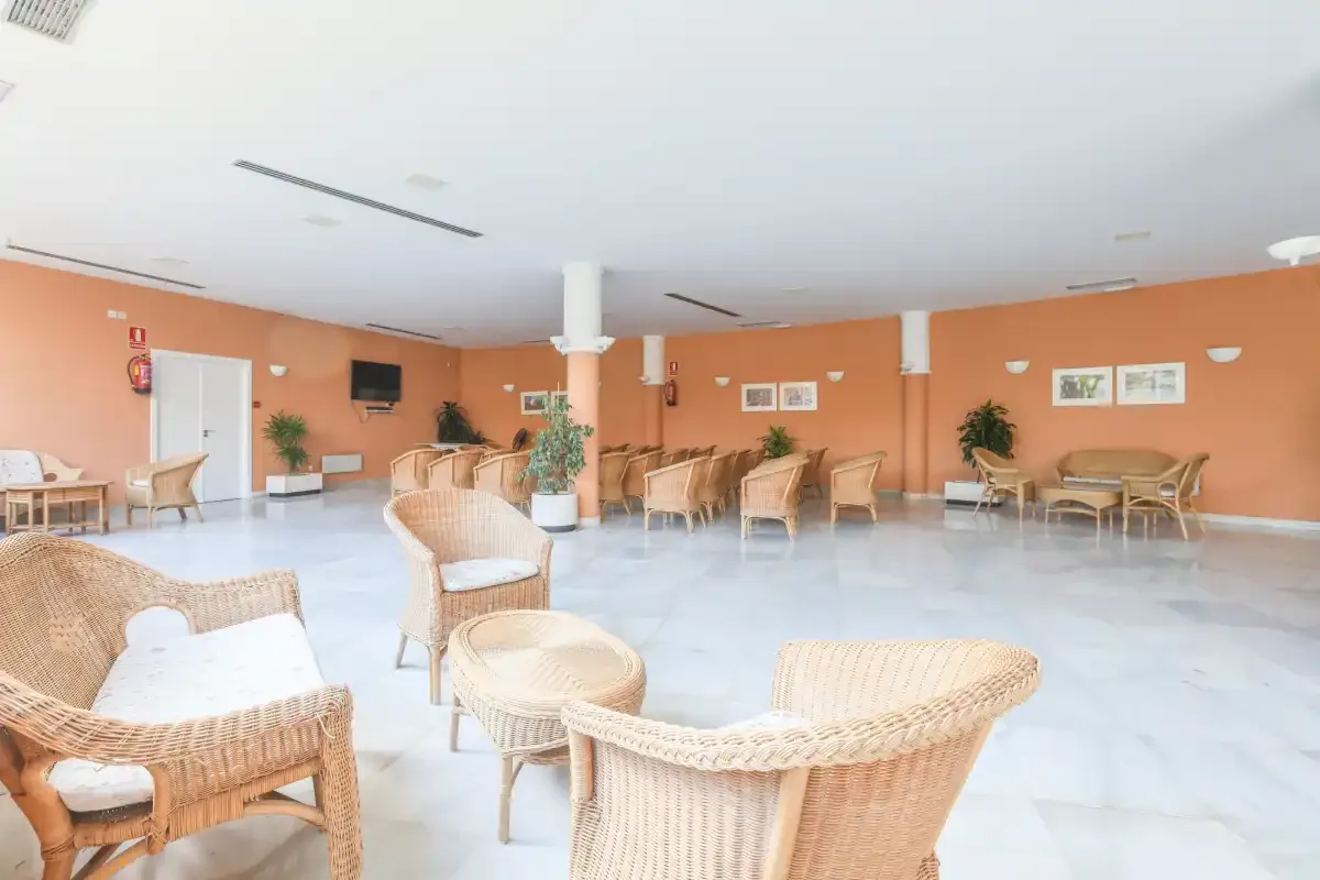 A spacious lounge with wicker seating arranged around the room.