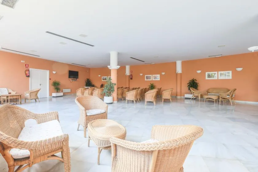 A spacious lounge with wicker seating arranged across a bright room.