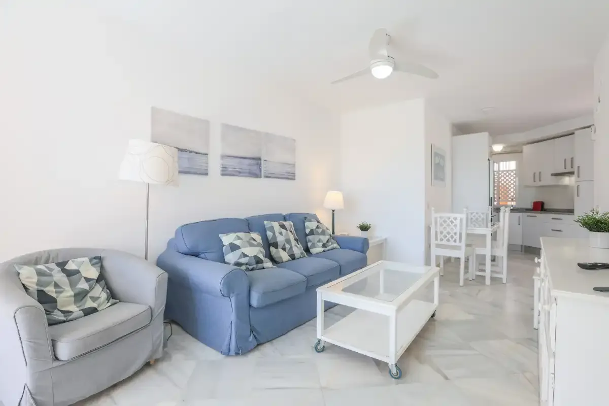 A bright living room with blue seating and a white coffee table.