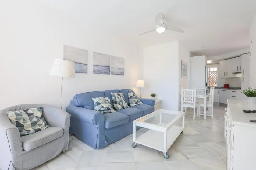 A bright living room with blue seating and a white coffee table.
