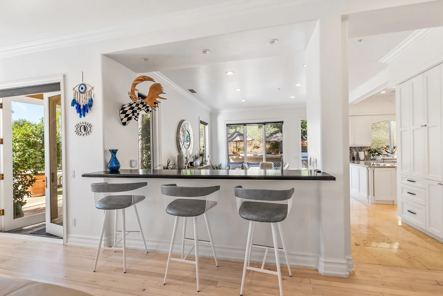 A bright kitchen with a long counter and seating overlooking the living area.