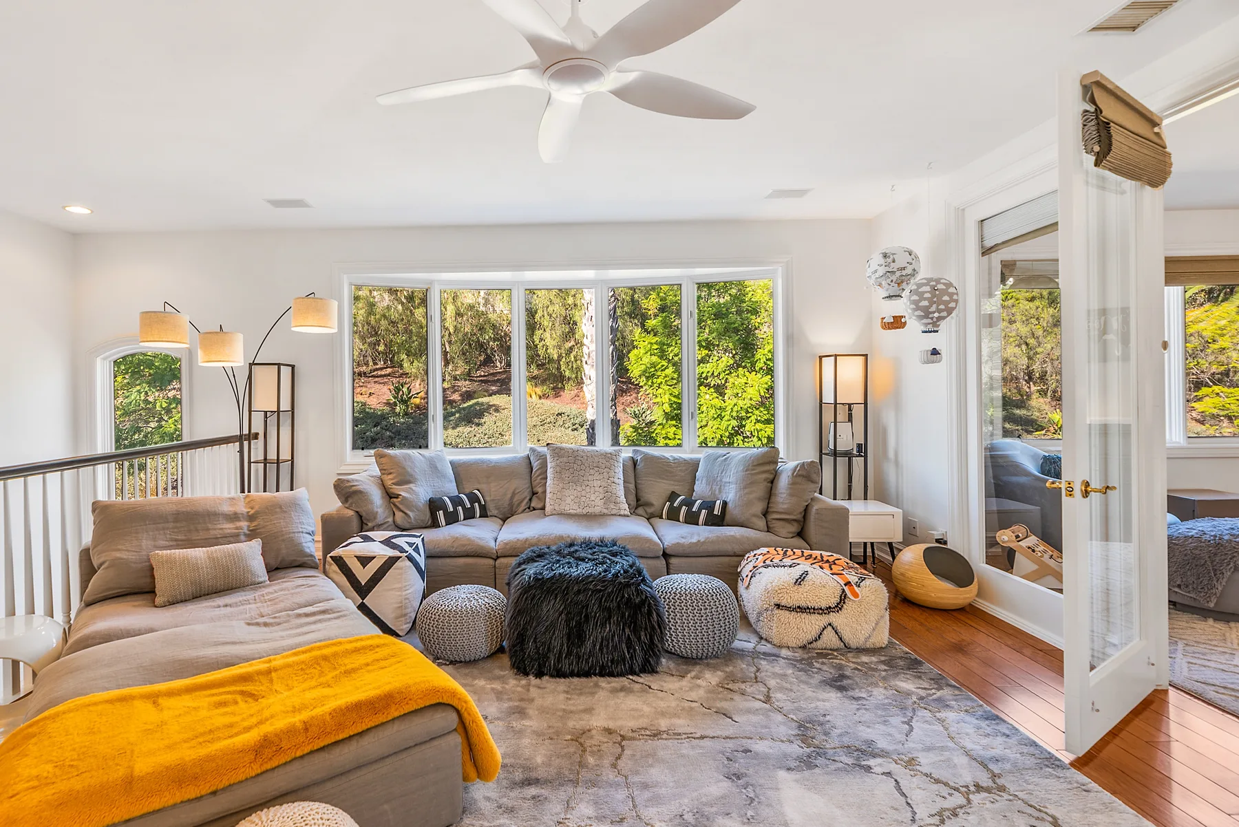 A bright living room with lounge seating arranged around a low coffee table.