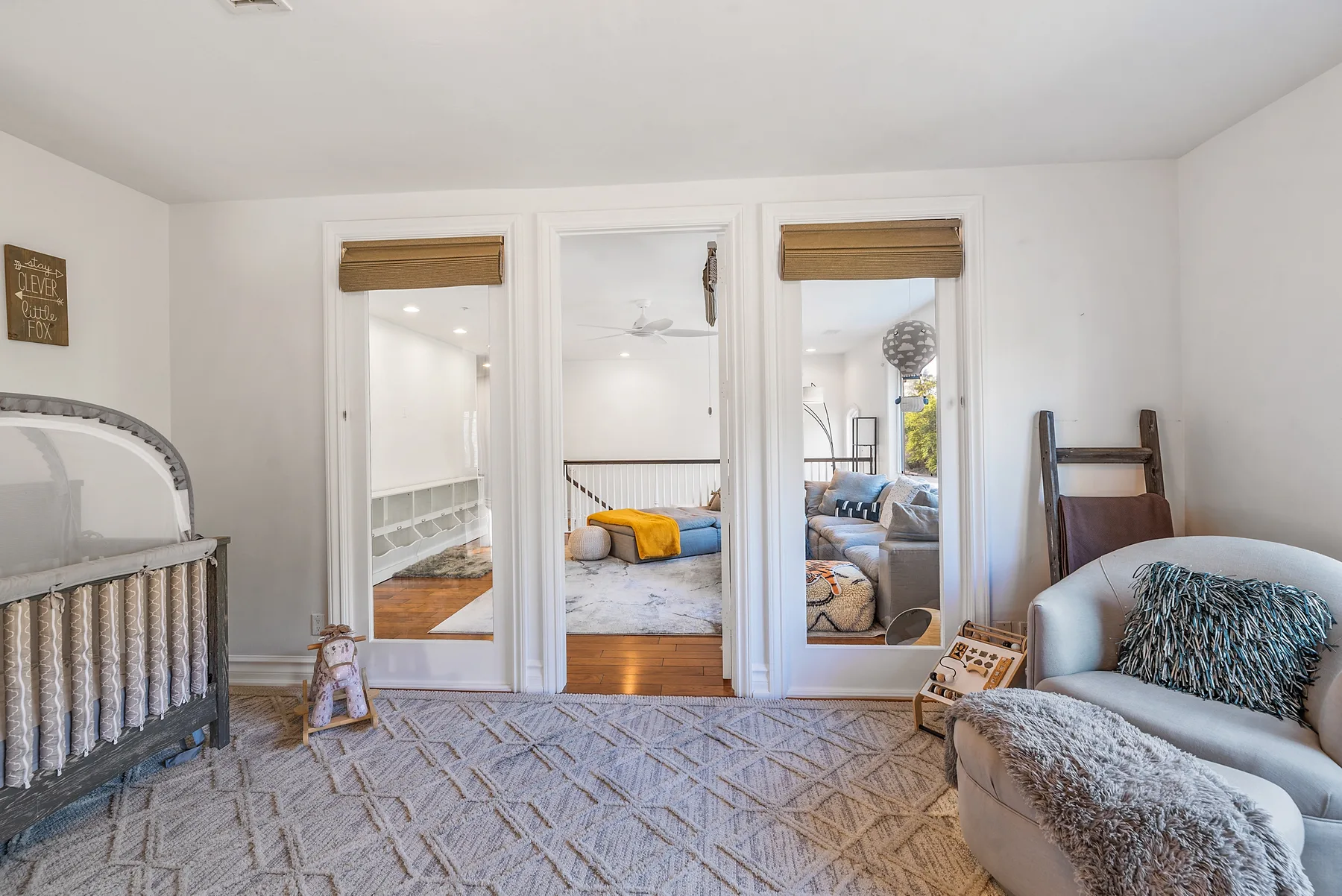 A bright bedroom with mirrored closet doors and a cushioned seating area.