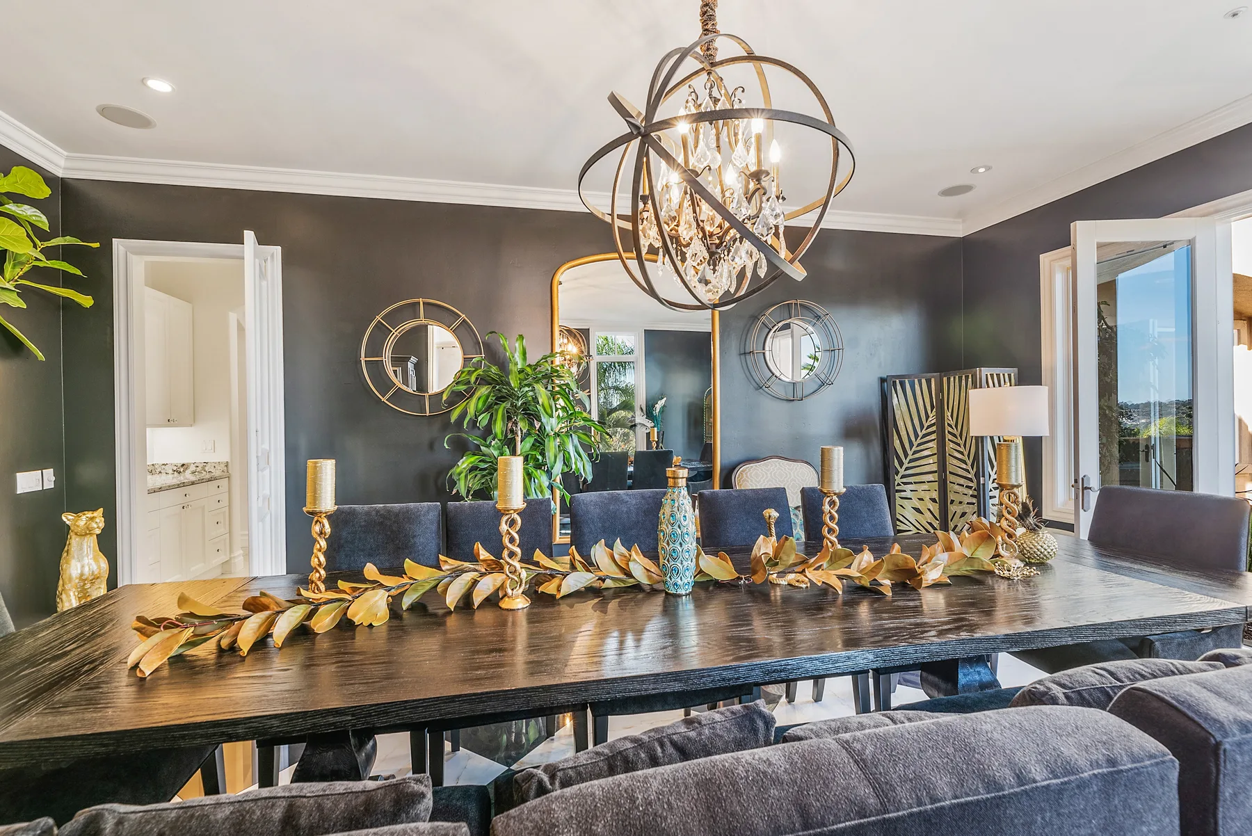 A dining room with a long table, chairs, and a decorative chandelier.